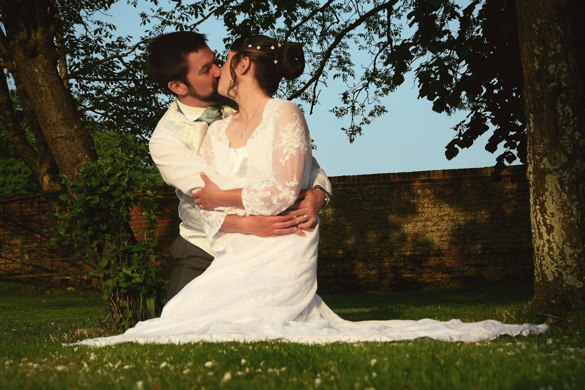 Emma and Mike kiss under trees.